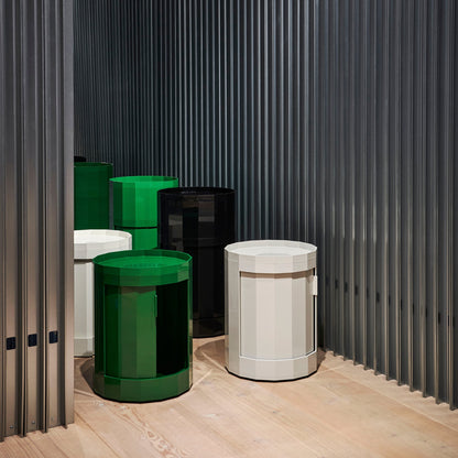 Groepje ronde kasten in groen, zwart, wit en lichtgrijs in een ruimte met geribbelde wand