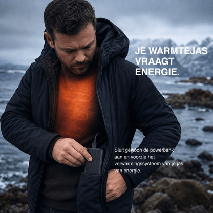 Man in donkere jas aan de kust stopt een powerbank in zijn zak, oranje gloed op zijn trui