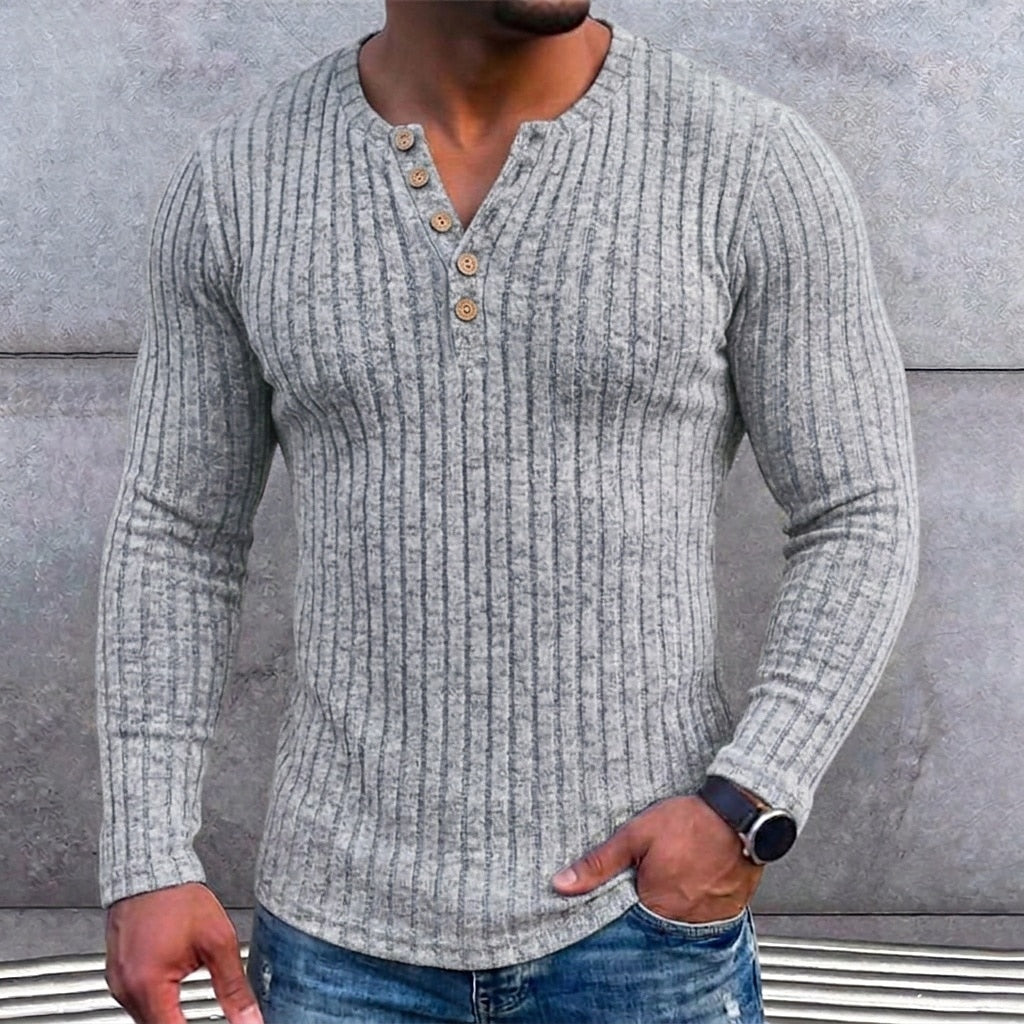 Grijs geribbeld shirt met knoopsluiting gedragen door een man met horloge en hand in de zak, detail