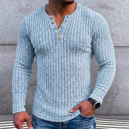 Lichtblauw geribbeld shirt met knoopjes gedragen door een man met horloge en spijkerbroek, detail