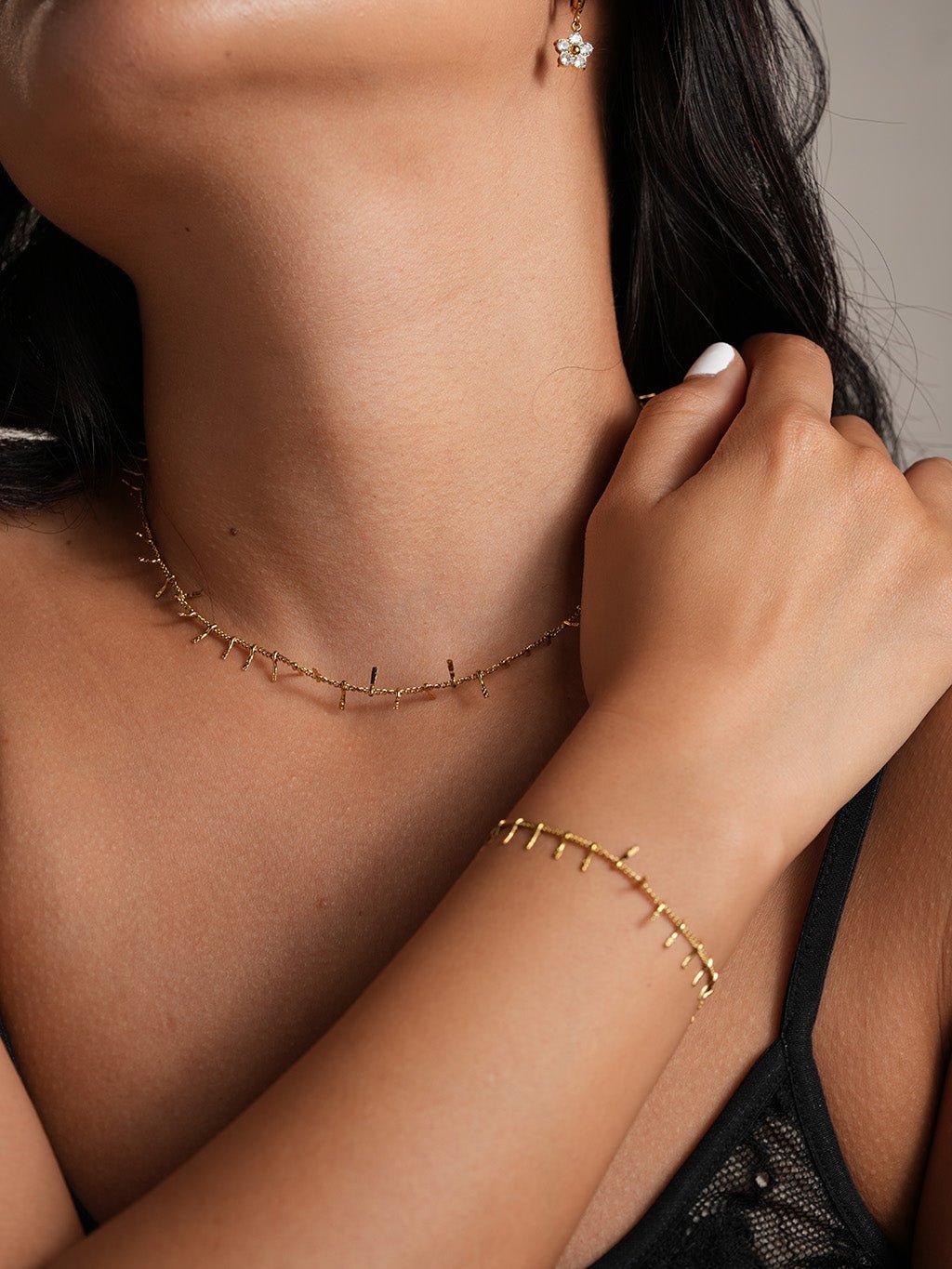 Sieradenset met ketting en armband, detail bij de hals van een model