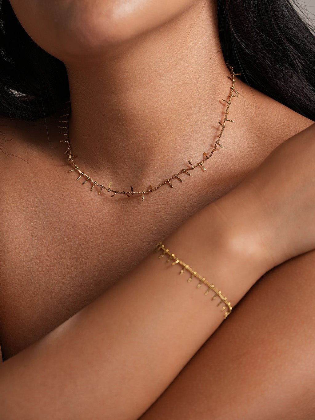 Sieradenset met ketting en armband gedragen door een model