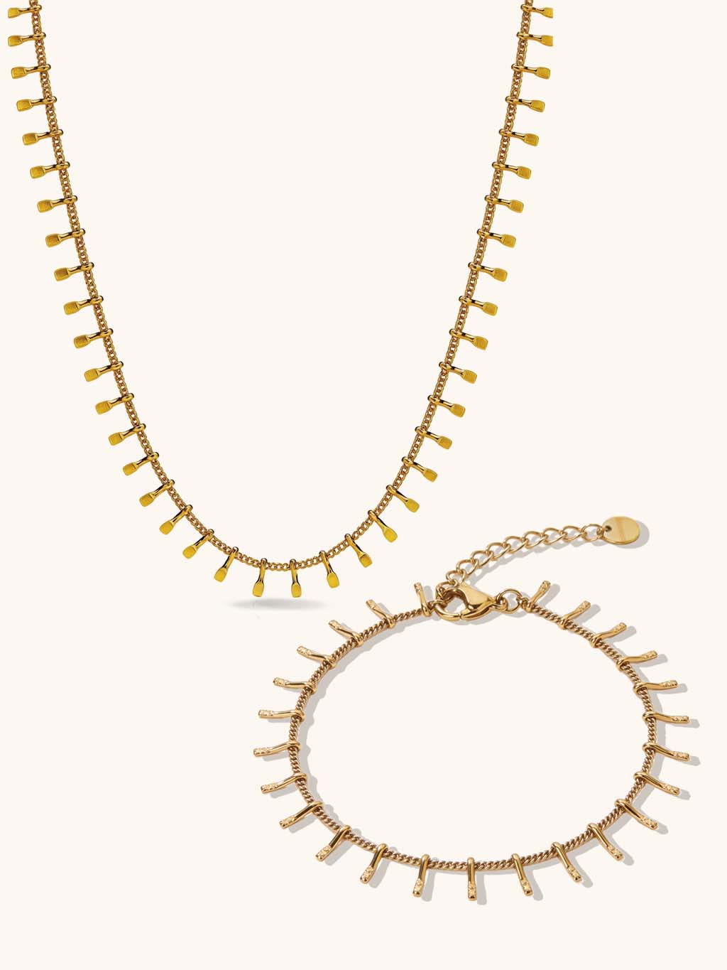 Sieradenset met ketting en armband in goudkleur op een lichte achtergrond