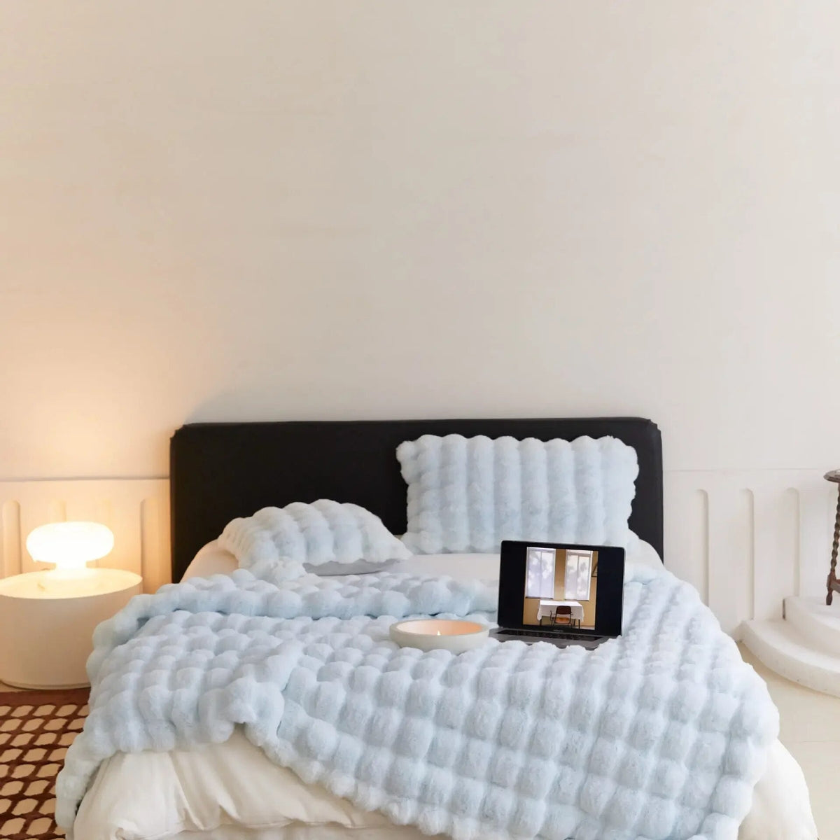 WarmWool lichtblauwe deken op een bed, detail