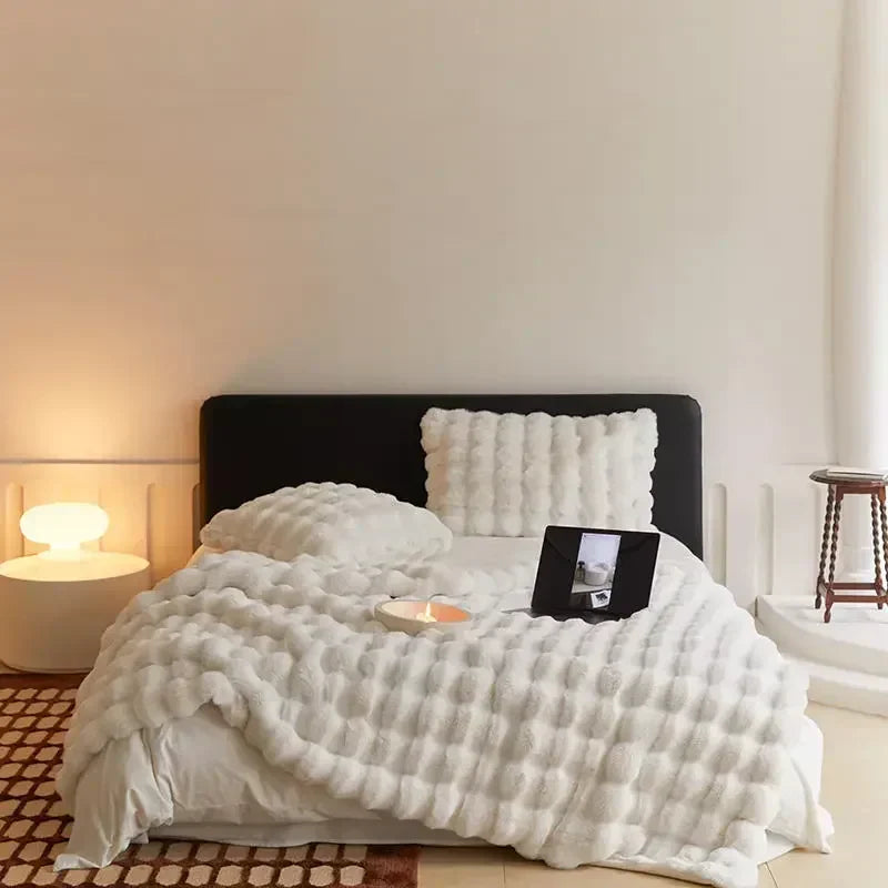 WarmWool witte deken met bolletjes op een opgemaakt bed, detail